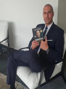 Oliver Martin Biography 21 OLIVER MARTIN Oliver Martin smiling while holding a book – public speaker and personal clarity advocate